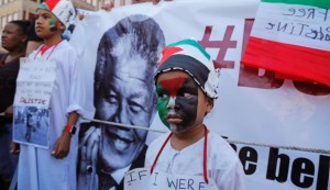 A child next to a picture of Nelson Mandela at a pro-Palestinian rally in Cape Town. August 9, 2014 / Photo by AP